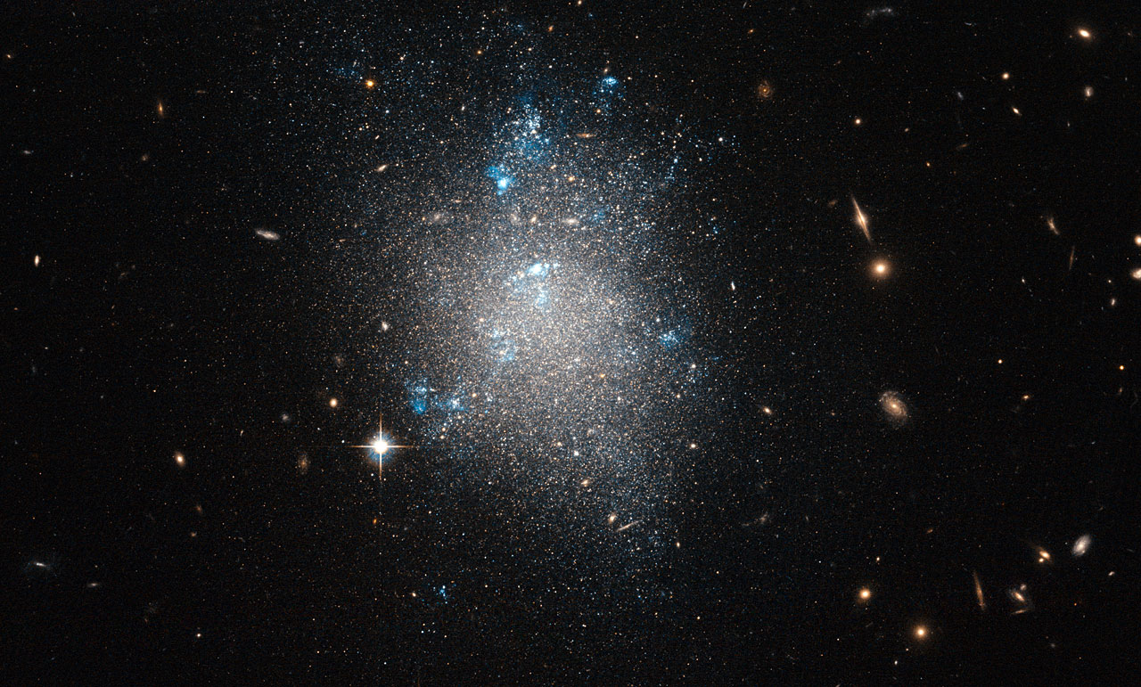 Hubble Catches a Tiny Galaxy Burning Off the Cosmic Fog, 1.4 Billion Years After the Big Bang